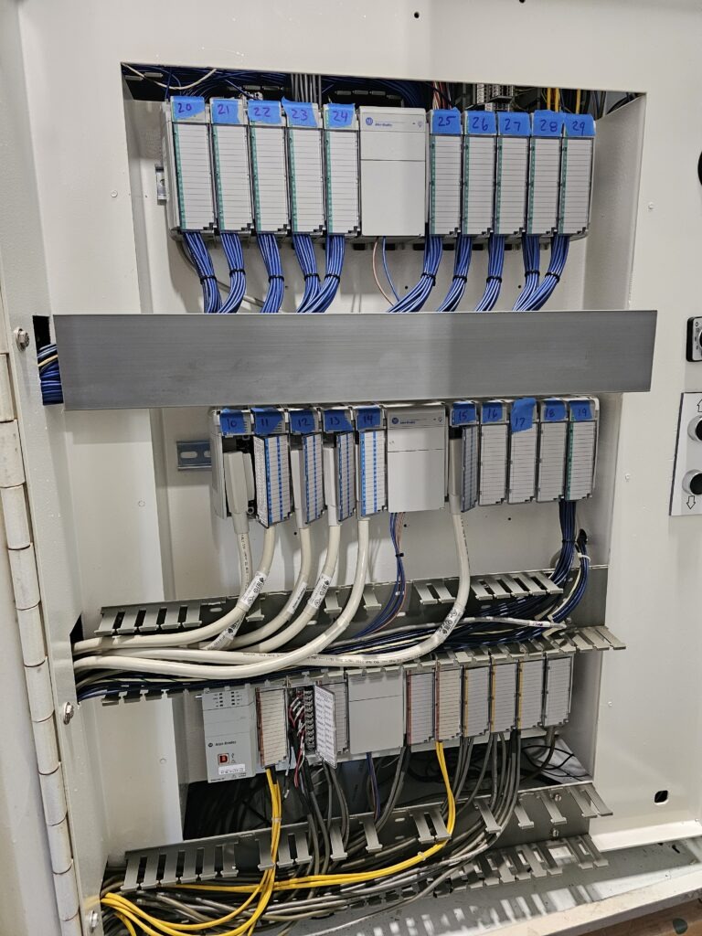 Control panel showing organized wiring and labeled modules for efficient equipment management and monitoring in an industrial setting.