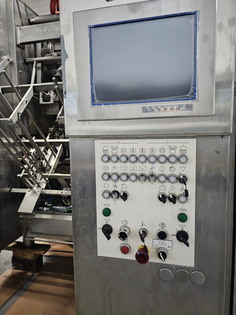 Control panel of an industrial machine featuring a monitor and various buttons