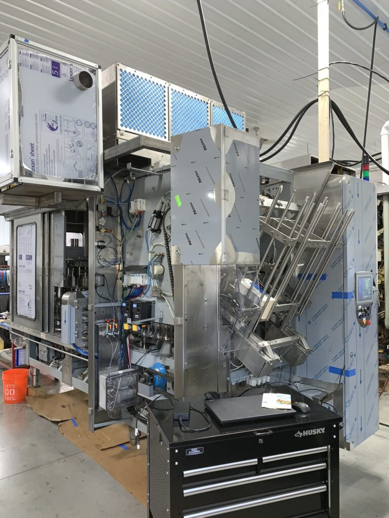 Industrial packaging machine with stainless steel components and intricate wiring