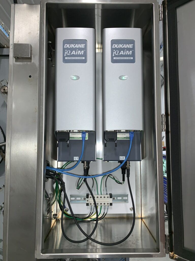 Dukane iQAiM automation control unit showing two devices with LED indicators, designed for industrial automation applications.